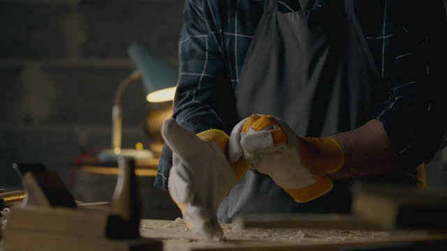 Crafts, Middle-aged builder Skillfully Puts gloves on work hands At work In slow motion Skilled