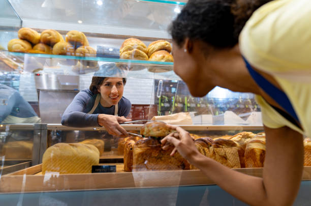 istock Retail clerk selling bread to a female customer 1623084577