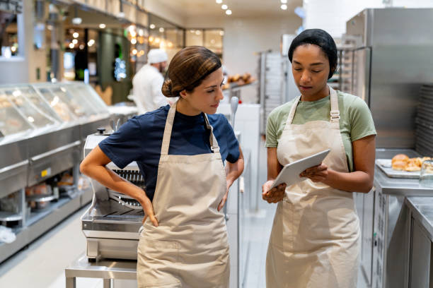 istock Female baker training a new employee at the bakery 1623085555