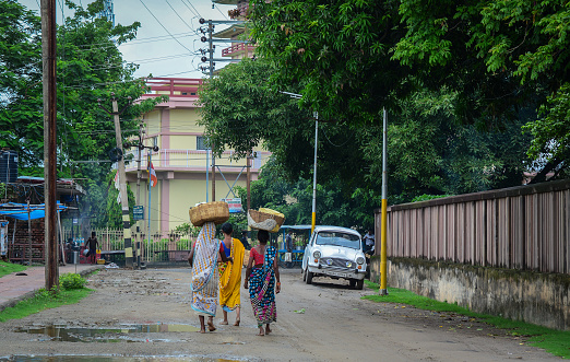 Bodhgaya, India - Jul 9, 2015. Local women walking on street in Bodhgaya, India. Bodh Gaya is considered one of most important Buddhist pilgrimage sites.