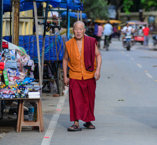 Bodhgaya, India - Jul 9, 2015. A Buddhist monk walking on street in Bodhgaya, India. Bodh Gaya is considered one of the most important Buddhist pilgrimage sites.