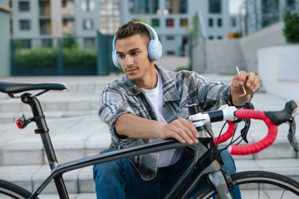istock Young man repairing a bike while sitting on the steps 1623093865
