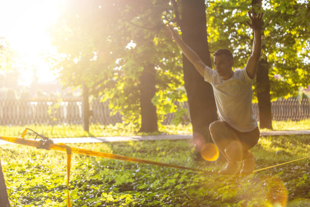 istock Young man balancing on the rope in the forest 1623095504