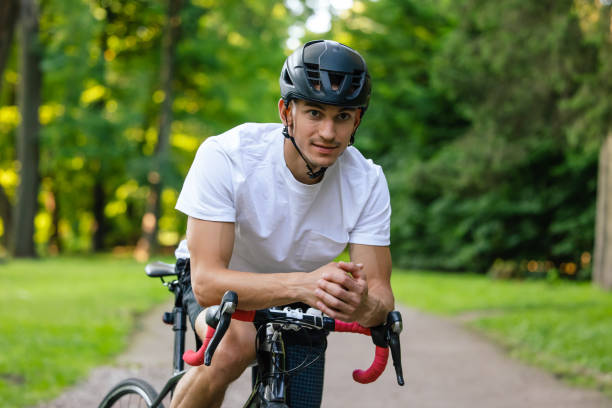 istock Young man in protective hemlet riding a bike in a park 1623095539