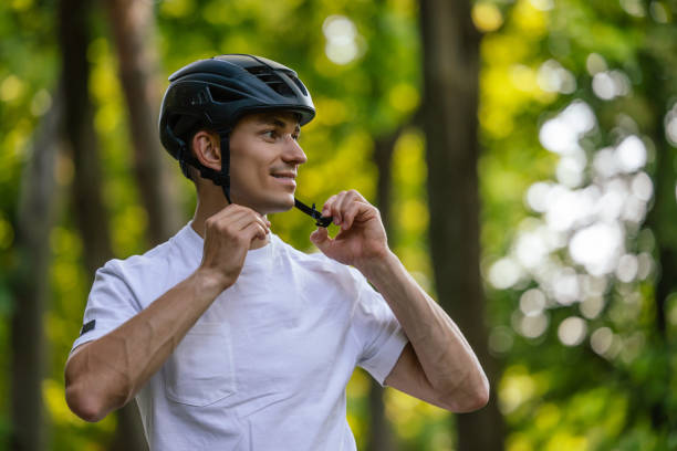 istock Young handsome cyclist putting on his protective hemlet 1623095901