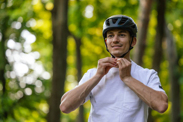 istock Young handsome cyclist putting on his protective hemlet 1623096064