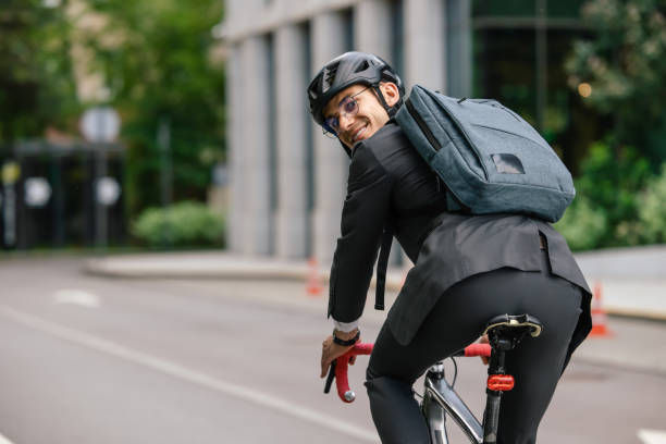 istock Young man in black suit riding a bike 1623097786