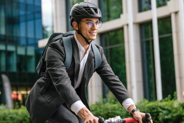 istock Young man in black suit riding a bike 1623097791