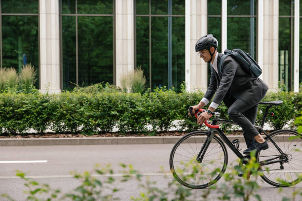 istock Man in hemlet and with a backpack riding a bike 1623098406