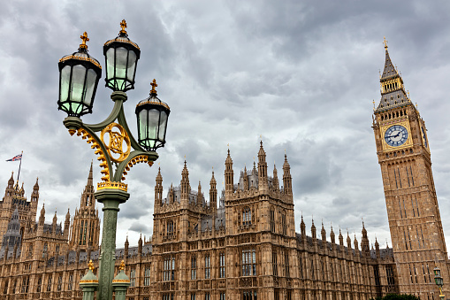 Big Ben in London with the houses of parliament and ornate street lamp on Westminster Bridge