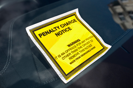 Penalty charge notice illegal parking fine attached to car windscreen