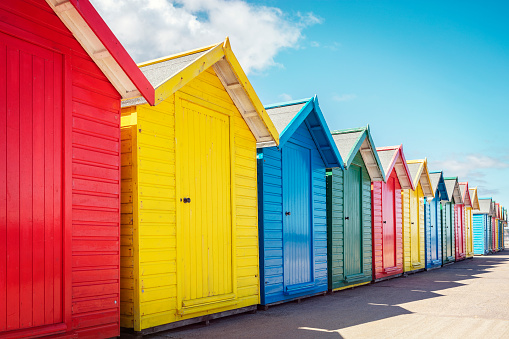 Beach huts or colorful bathing boxes on the beach with blue sky background