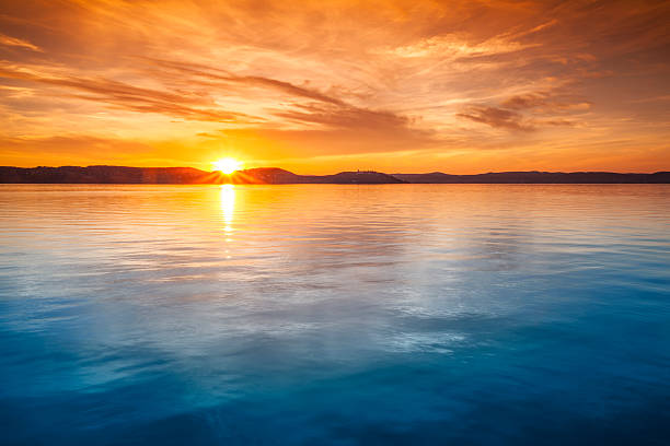 закат над водой - golden sunset стоковые фото и изображения