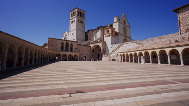 Tracking along the lower plaza towards the Basilica of St Francis of Assisi, Italy