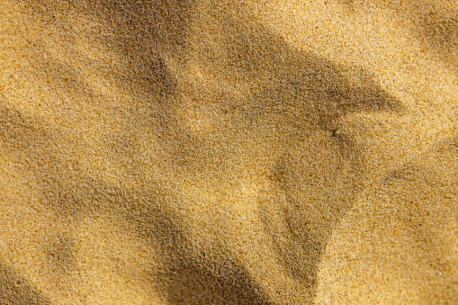 Copacabana, Rio de Janeiro, Brazil - June 12, 2016: View of the symbolic sidewalk of Copacabana with people, a sand castle, a Brazilian flag, the beach and the structures of the future Olympic beach volleyball complex.