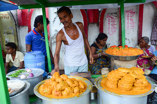Bodhgaya, India - Jul 9, 2015. Unidentified people selling street foods in a crowded market in Bodhgaya, India. Its a common practice in India to sell vegetables in open markets and streets.