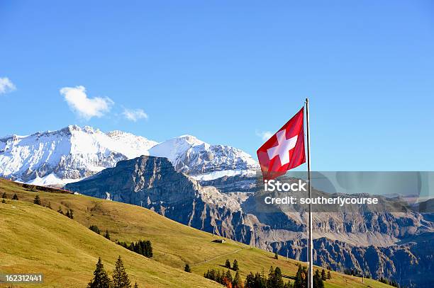 Swiss Flag In Front Of Bernese Alps Panorama Stock Photo - Download Image Now - Swiss Flag, Switzerland, Swiss Culture