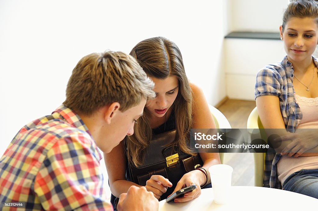 Étudiants regardant de Smartphone assis de cafétéria - Photo de Adulte libre de droits