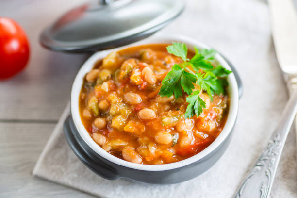 Cooked white beans with zucchini and other vegetables.