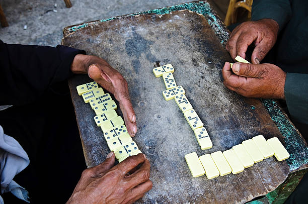 Two men playing dominoes at a street cafe in Rashid (Rosetta), Egypt. The oldest known domino set was found in the tomb of Tutankhamen who ruled Egypt in the 14th century BC.