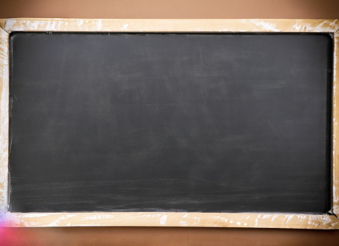 Empty blackboard with picture frame in classroom for creative presentations and learning. Copy space