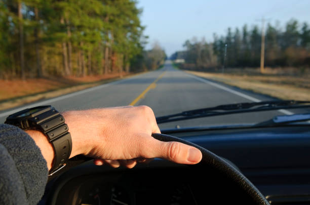 istock Highway driving with hand on steering wheel on two-lane road 162314777