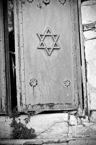 An old, worn door with the Star of David on the front, slightly ajar, in Safed, Israel