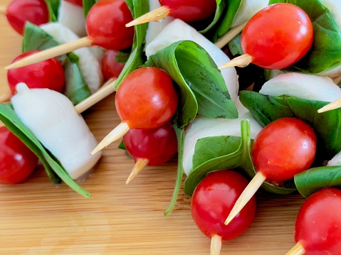 Snack of tomato, basil and cheese on a tooth pick