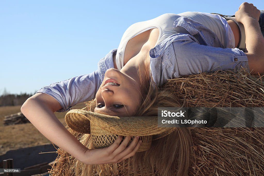 Vaqueira sorridente Postura de Hay Bale - Royalty-free Camisa com botões Foto de stock