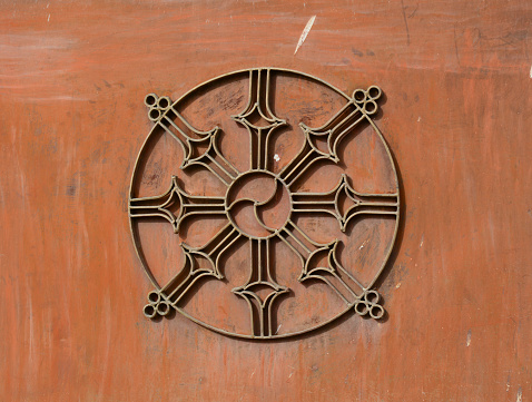 Dharma Wheel Buddhist symbol in old door in Ladakh, India.