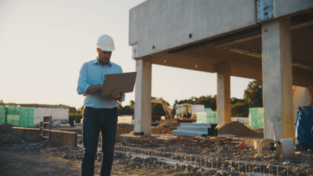 istock Male engineer at construction site with laptop during sunset 1623197491