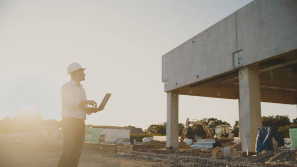 istock Male project manager diligently works on his laptop at bustling construction site 1623197510
