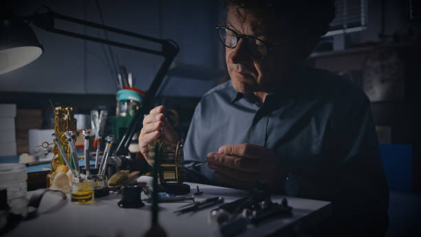 istock Mature male mechanic analyzing gear of clock at a table 1623204060
