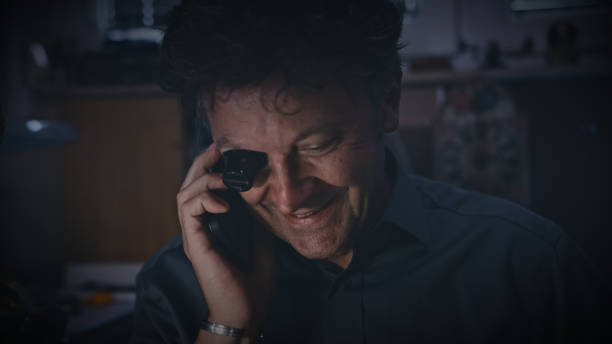 istock Mechanic wears a magnifying glass while talking on smart phone. Watch Maker 1623204385