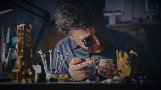 ekspert nosi szkło powiększające podczas analizy sprzętu zegarka na rękę - male magnifying glass caucasian technician zdjęcia i obrazy z banku zdjęć