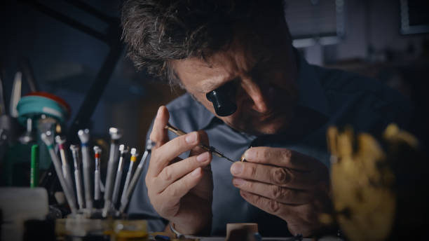 istock Craftsman wears a magnifying glass while fixing the gear at workplace 1623205060