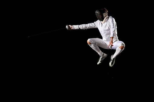 Fencer in a fencing pose. White on black background.