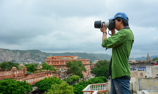 Jaipur, India - Jul 27, 2015. A young photographer taking pictures cityscape of Jaipur, India.