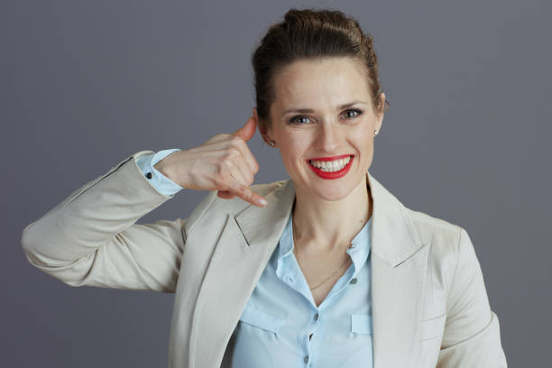 istock smiling stylish female employee showing call me gesture 1623219963