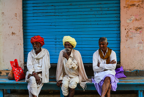 Pushkar, India - Nov 5, 2017. People sitting on street in Pushkar, India. Pushkar is a town in the Ajmer district in the state of Rajasthan. It is a pilgrimage site for Hindus and Sikhs.