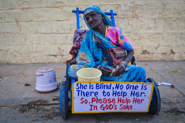 Pushkar, India - Mar 3, 2012. A beggar waits for alms on the ghat along the sacred Sarovar lake in Pushkar, India.