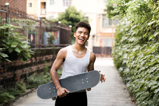 Asian teenager who loves to laugh on skateboarding