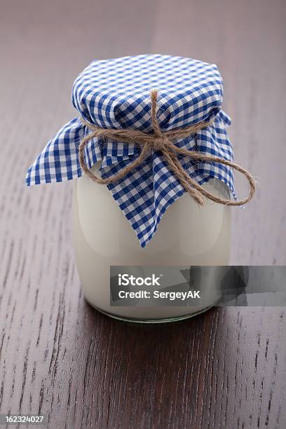 Homemade Milk Yogurt In Glass Pot On Wooden Table Stock Photo - Download Image Now - Breakfast, Checked Pattern, Cooking Pan