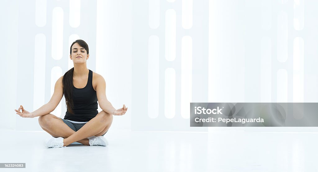 Donna facendo yoga in uno spazio moderno, - Foto stock royalty-free di Abbronzatura