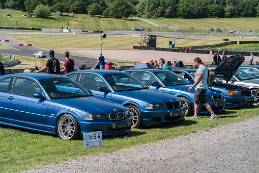 Tarporley, Cheshire, England, June 3rd 2023. Row of Blue Classic BMWs at a classic car meet, automotive lifestyle editorial illustration