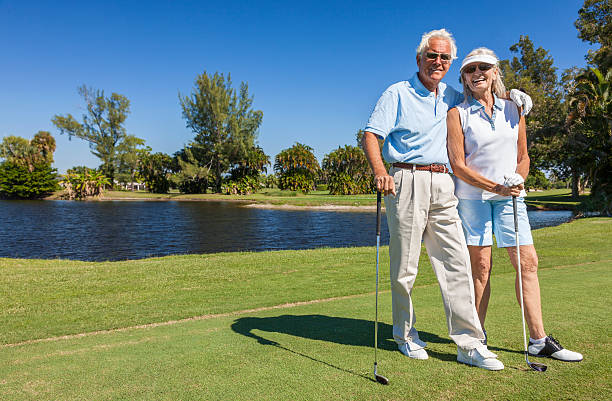 glücklich altes paar spielen golf - senior adult healthy lifestyle athleticism lifestyles stock-fotos und bilder