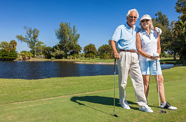 feliz casal sênior jogando golfe - couple senior adult travel action - fotografias e filmes do acervo