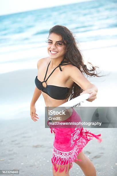 かわいいヒスパニック雌フリスビーで遊ぶビーチ - フライングディスクのストックフォトや画像を多数ご用意 - フライングディスク, 浜辺, アクティブライフスタイル