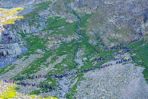 August 12, 2023; Popradske Pleso, Slovakia: A crowd of tourists waiting in a queue to the mountain chains on a trail to the Rysy peak in the High tatras.