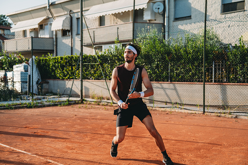 A tennis player during a match. Orange tennis field.